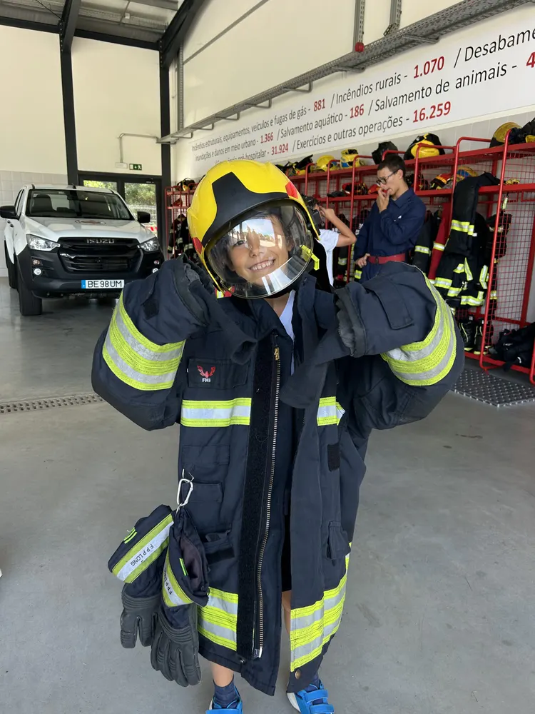 Criança vestida de bombeiro, na visita ao quartel